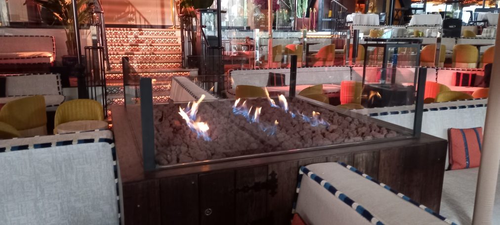 Mesa con fogones encendidos en un ambiente de restaurante acogedor.